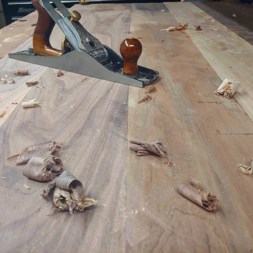 Walnut panel glue up with hand planer and wood shavings.